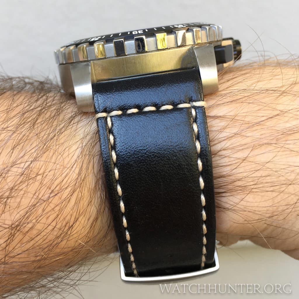 The original leather strap with deployment buckle